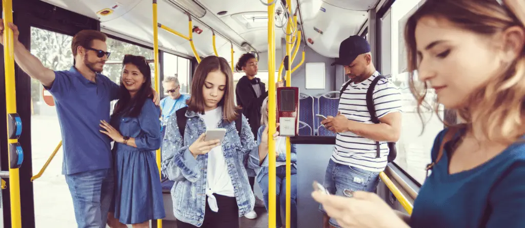 A group of people on public transport, many using their phones